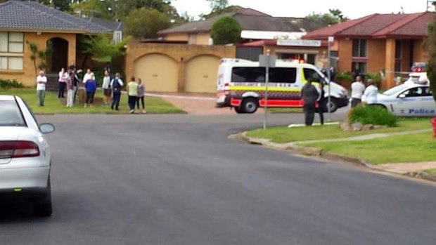 Residents gather after a man was arrested for allegedly committing a terrorist act. 