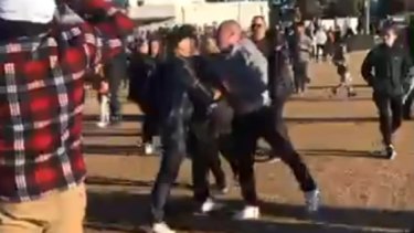 Spectators fighting after an umpire was chased from the ground at a junior football game.