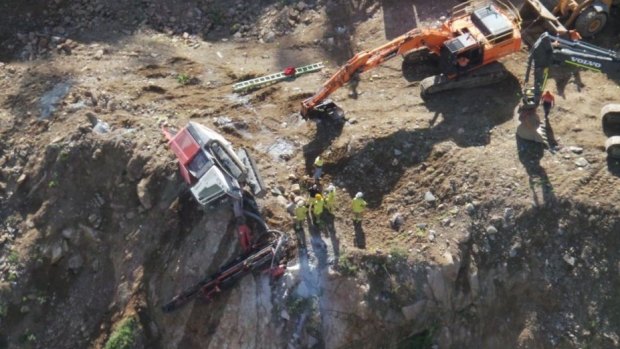 Crews rush to rescue a worker trapped in an excavator at a quarry in Keperra.