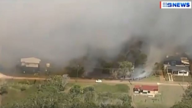 Houses are under threat from an uncontrolled bushfire on Russell Island.