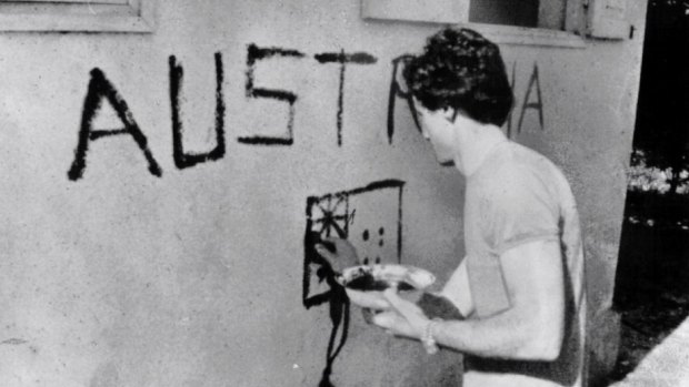 Greg Shackleton paints "Australia" on a shop wall in Balibo in East Timor in 1975. He and five other journalists were killed while covering Indonesia's invasion.