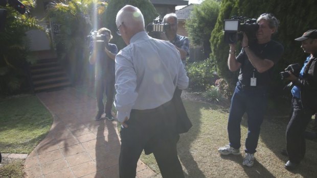 The media pack watch Paul Kenny enter Roger Rogerson's home.