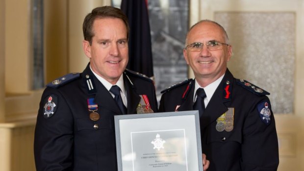 MFB commander Graeme O'Sullivan (left) receiving a Chief Commendation from former Acting Chief Officer Paul Stacchino.