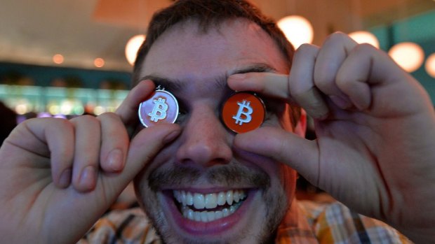 Currency wobbles: James MacWhyte, a member of bitcoin trading club poses with bitcoin medals at the club's meeting in Tokyo.
