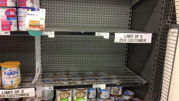 A Woolworths shelf emptied of popular Australian infant formula brands. The supermarket has imposed an eight-tin limit.
