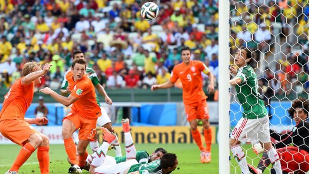 Goalkeeper Guillermo Ochoa of Mexico makes a save after a shot at goal by Stefan de Vrij.