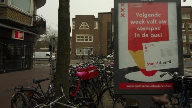 "Next week your voting card's coming in the mail! Vote April 6," a sign reads in Amsterdam.