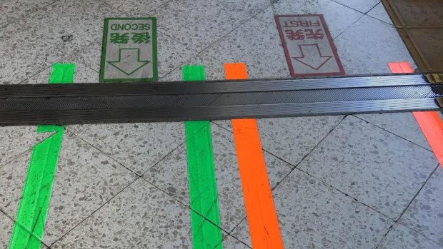 The painted lines on the floor of a Japanese train station instructing passengers where to wait.
