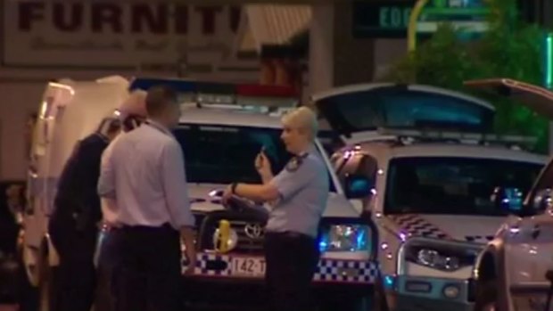Police investigate after one of their colleagues shot a man at a Townsville service station. 