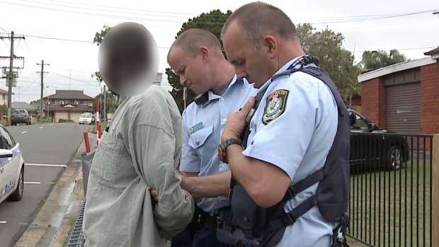 A man is arrested by police outside Bennett Road Public School in Colyton.