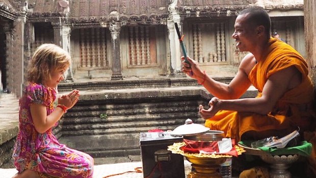 Emmie receiving a blessing from a monk at Angkor Wat.