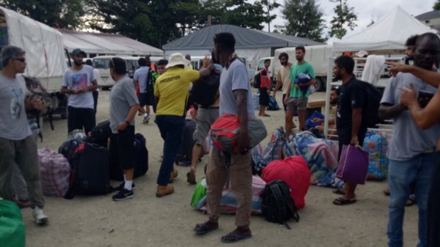 PNG immigration officers lead people out of the decommissioned detention centre on Friday.
