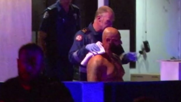 Radwan Zraika, the first victim of three western Sydney shootings in March, being escorted to an ambulance. 