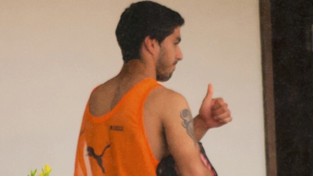 Heading home: Uruguay's Luis Suarez gives a thumbs-up from a balcony of the team's hotel.