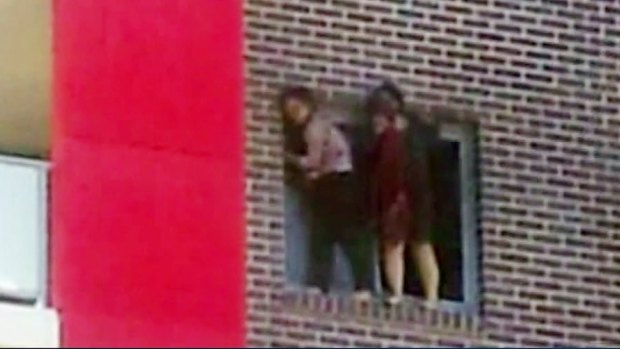 Ping Kang "Connie" Zhang and Yinuo "Ginger" Jiang hang on to the window of their Bankstown flat before jumping to escape the fire.