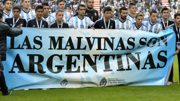 Argentina's footballers pose for photographers holding a banner reading "The Malvinas / Falkland Islands before friendly against Slovenia.