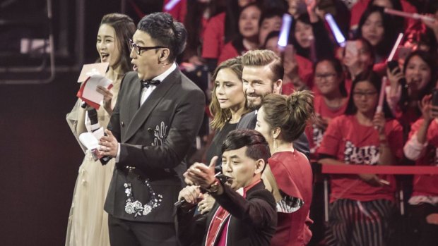 Soccer star David Beckham and wife Victoria Beckham appear on stage with the hosts of Alibaba's Singles' Day countdown event. 