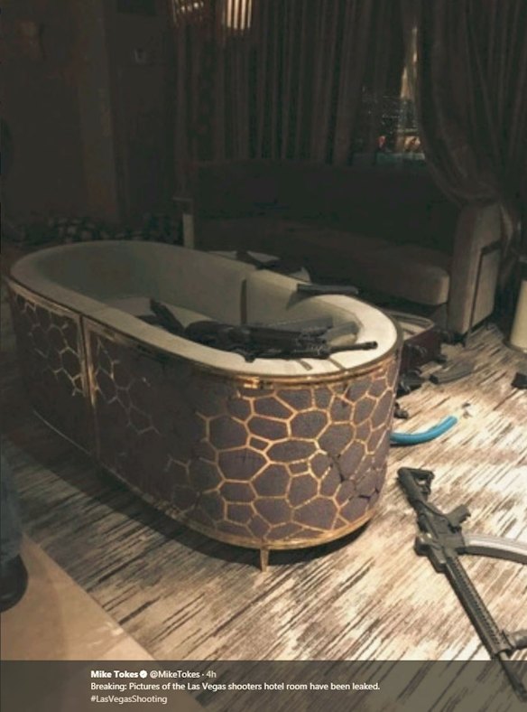 Suitcases, assault rifles and magazines can be seen strewn around the floor of the hotel room.