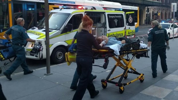 The victim of the assault on Ann Street is stretchered away by paramedics.
