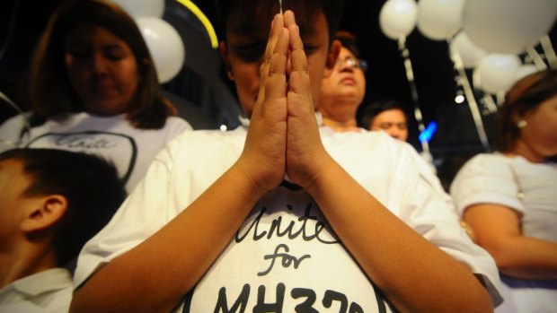 Hope: A young Malaysian boy prays at an event for the missing Malaysia Airlines plane in Kuala Lumpur in March 2014.