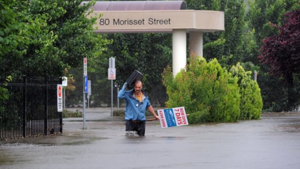  Dr David Poland leaves his flood-affected surgery in Morisset Street, Queanbeyan, during the 2010 flood.