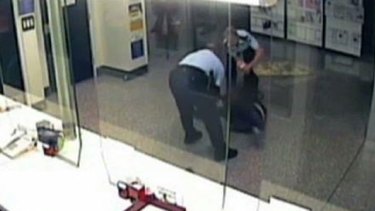 Two officers drag the woman across the floor, an image from the footage shows.