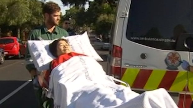 Paramedics treat a 73-year-old woman who was allegedly attacked at Hawthorn station on Thursday.