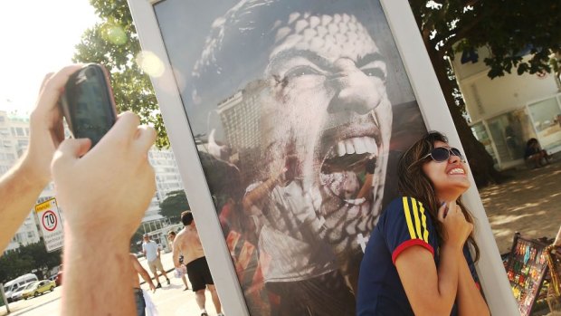 A woman takes a photo next to an advertisement featuring Uruguay's Luis Suarez.