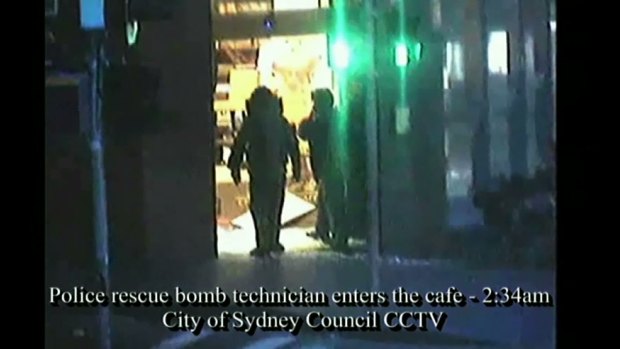 Bomb squad technicians enter the cafe after the siege.