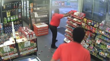 Service station attendant throws bags of lollies to stop an aborted robbery.