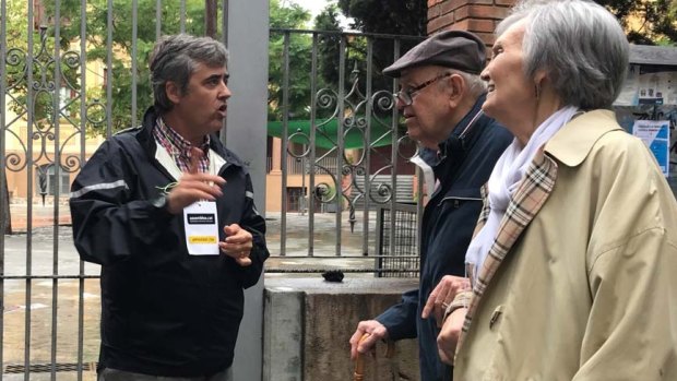 Polling station volunteer Marc Carrasco talks to voters in Barcelona.