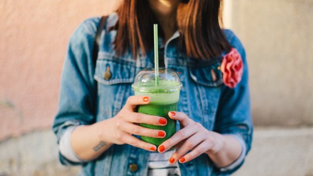 Woman holding a smoothie.