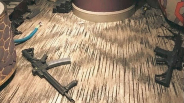 Photos from inside the hotel room show some of the 23 guns Paddock had as well as magazines and bullets strewn around.
