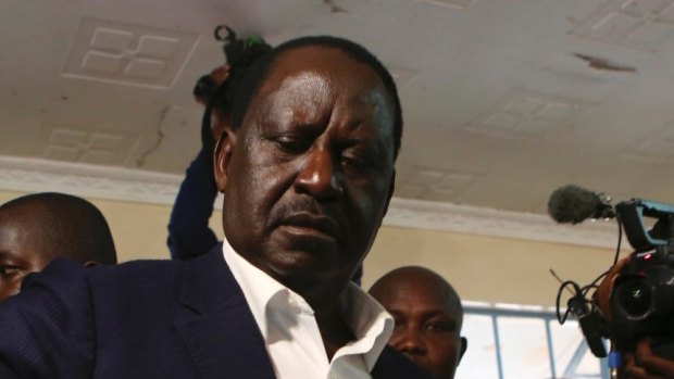 Kenyan Opposition leader Raila Odinga, second left, casts his vote.