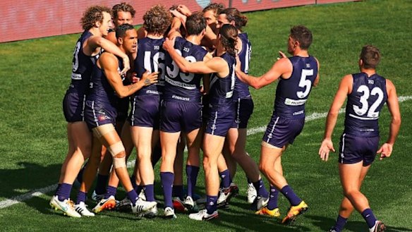 Fremantle players swamp Matthew Pavlich after he kicks his 700th goal.