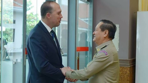 Australian Immigration Minister Peter Dutton and Cambodian Department of Immigration director-general Sok Phal shake hands in Phnom Penh.