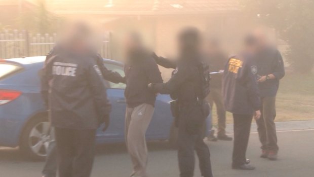 Australian Federal Police arrest a man during a raid on an Islamic store in Logan in 2014. 