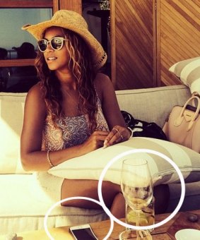 An iPhone and wine glass appear out of shape, which lead some to believe is an attempt to slim down her thigh.
