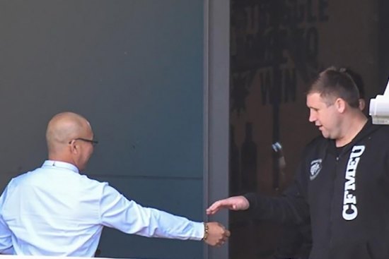 Former CFMEU NSW assistant secretary Michael Greenfield (right) and secretary Darren Greenfield (left, obscured) at union headquarters with an employer they received $5000 bribes from.