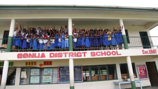 Children wave from the balcony of Conua District School.