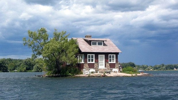 Just Enough Room Island just about manages to hold a cottage, a tree, shrubs and a tiny beach patch.