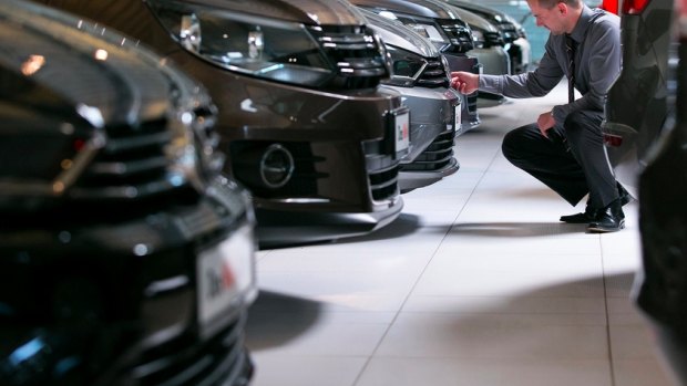 An employee inspects a Volkswagen car at a VW showroom in Germany.