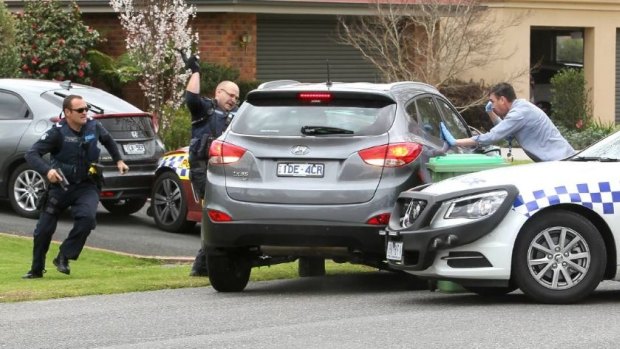 Police desperately try to smash the windows of the stolen Wodonga car after their vehicles were rammed.