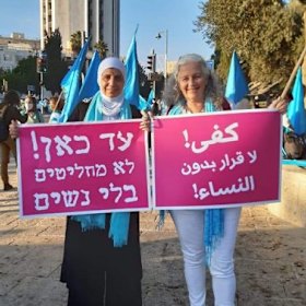 Women Wage Peace supporters carry a sign in Arabic and Hebrew that reads: “From now on, no one decides anything without women.”