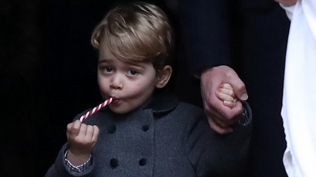 Prince George eats a sweet as he leaves following the Christmas Day service at St Mark's Church in Englefield.