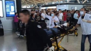 Emergency crews whisk away an injured person at Shanghai Airport.