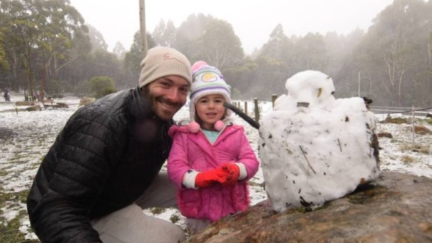 Matt and Eden Hibbert take advantage of the snow to build a snowman.