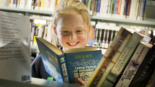 Lily Davis, 10, reading one of her favourite books <i>Diary of a Wimpy Kid</i> at the Ballarat Library.