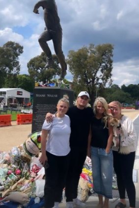 Shane Warne’s children and ex-wife Simone Callahan pose for a photo next to his statue outside the MCG. 