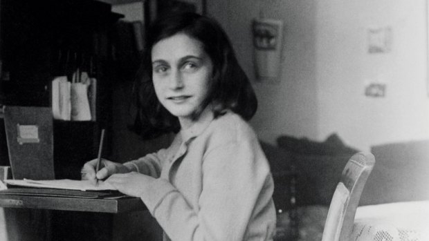 Anne Frank at her desk in her house in Amsterdam. 